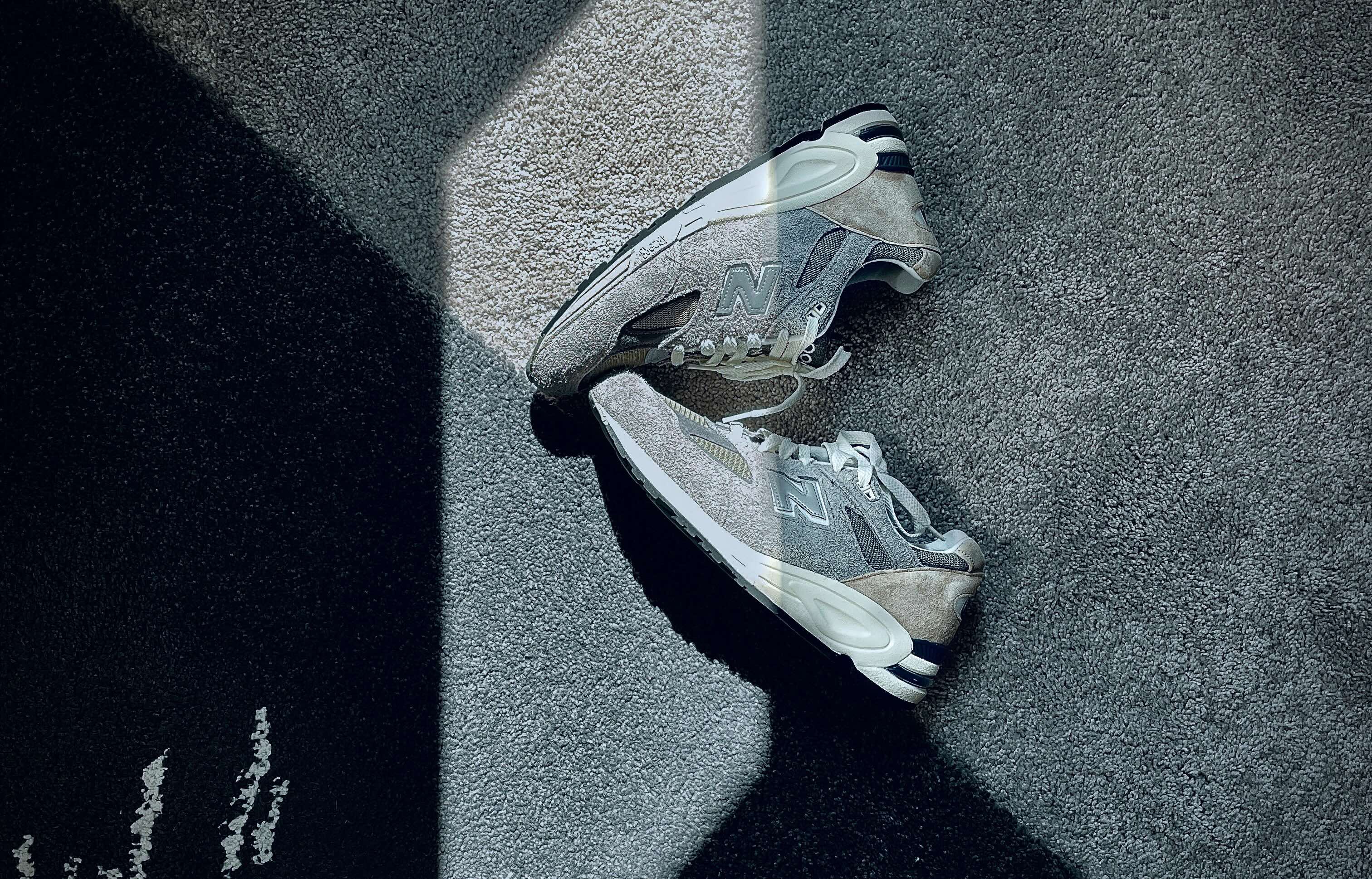 Gray New Balance sneakers on a gray/black backdrop
