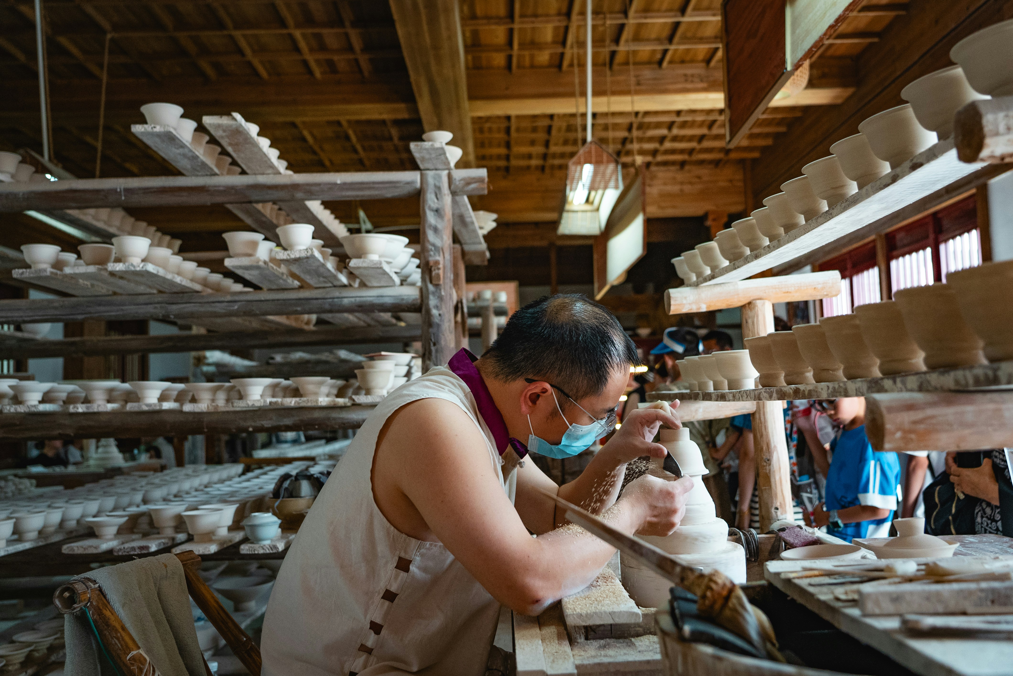 A Japanese potter making a bowl in his workshop