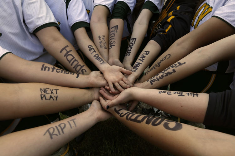 Multiple arms forming a circle, all reaching toward a central point, with black words written on each forearm.